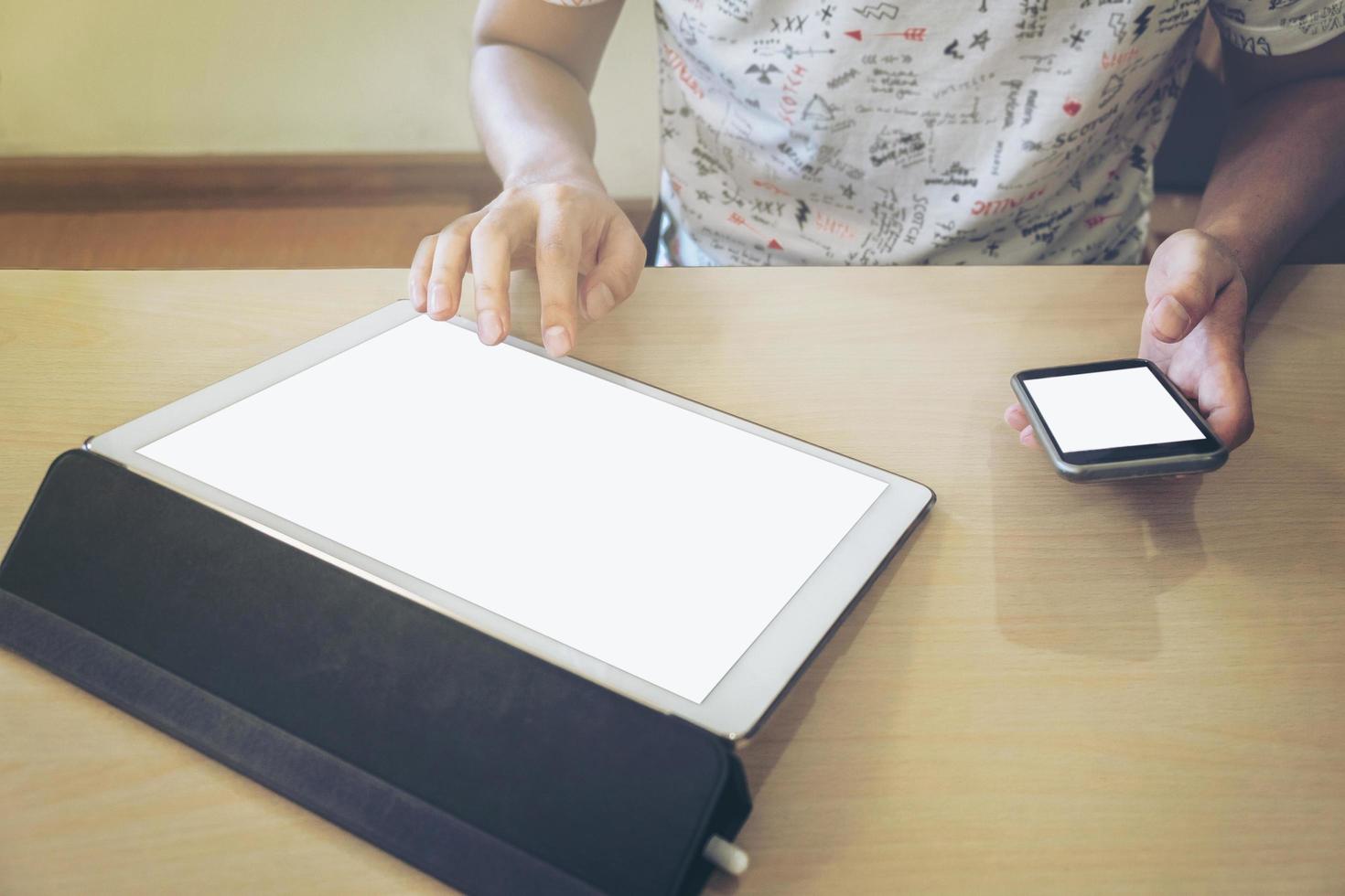 gros plan d'un homme d'affaires utilisant une tablette et un téléphone intelligent pour travailler des données financières. photo