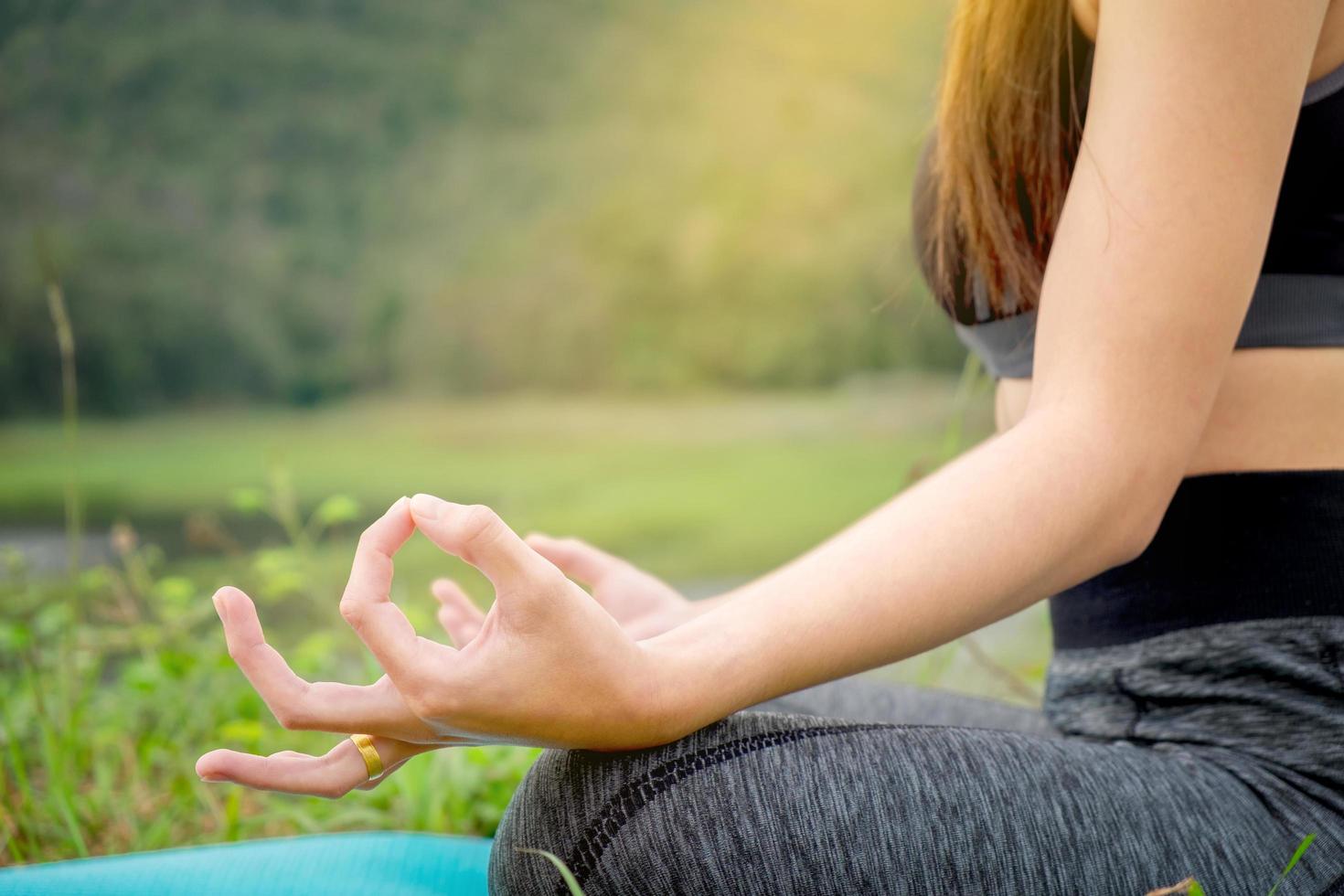 jeune femme assise yoga près de la rivière. concept de mode de vie sain et de détente. photo