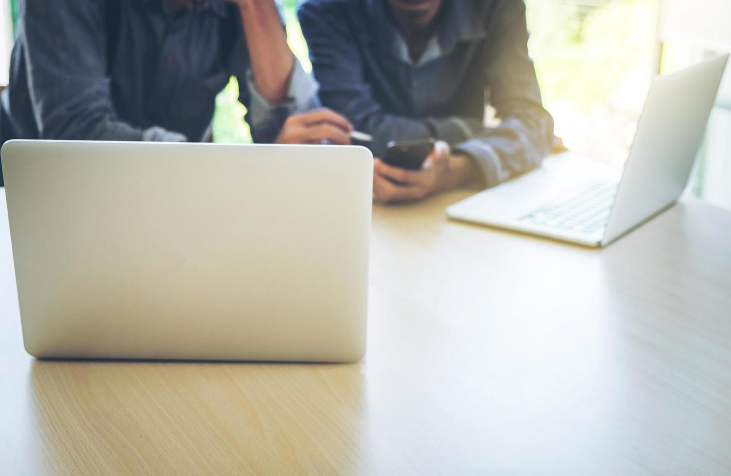 processus de travail d'équipe d'entreprise, mains d'hommes d'affaires pointant vers un téléphone intelligent et un document lors de l'explication des données du projet de nouveau plan lors de la réunion. photo