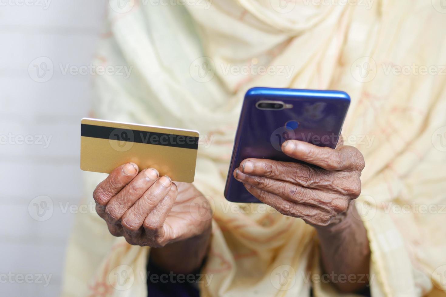 femmes âgées tenant une carte de crédit et utilisant un téléphone intelligent pour acheter en ligne photo