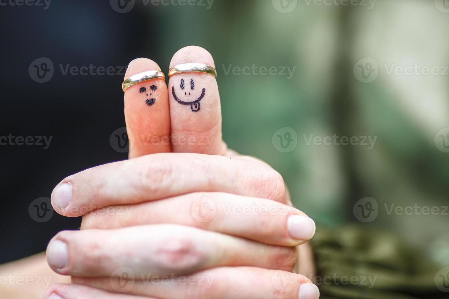 anneaux de mariage sur les doigts peints avec la mariée et le marié, petits hommes drôles photo