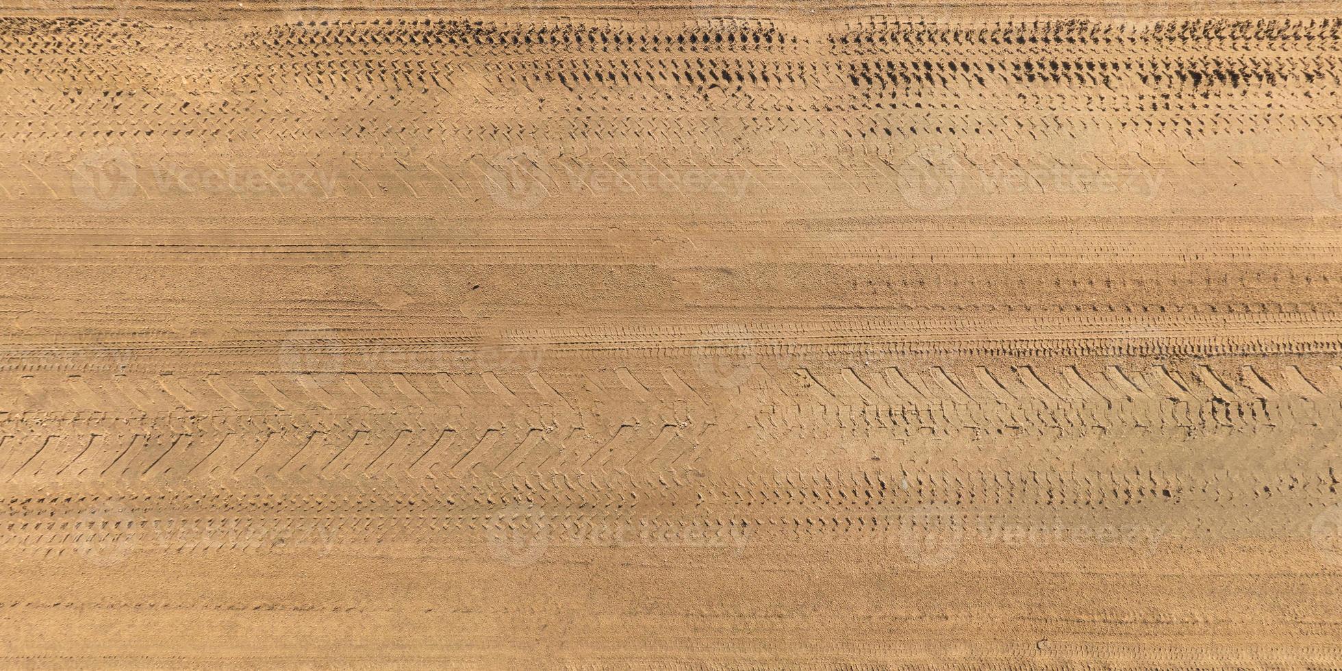 vue d'en haut sur la texture de la route de gravier avec traces de pneus de voiture photo