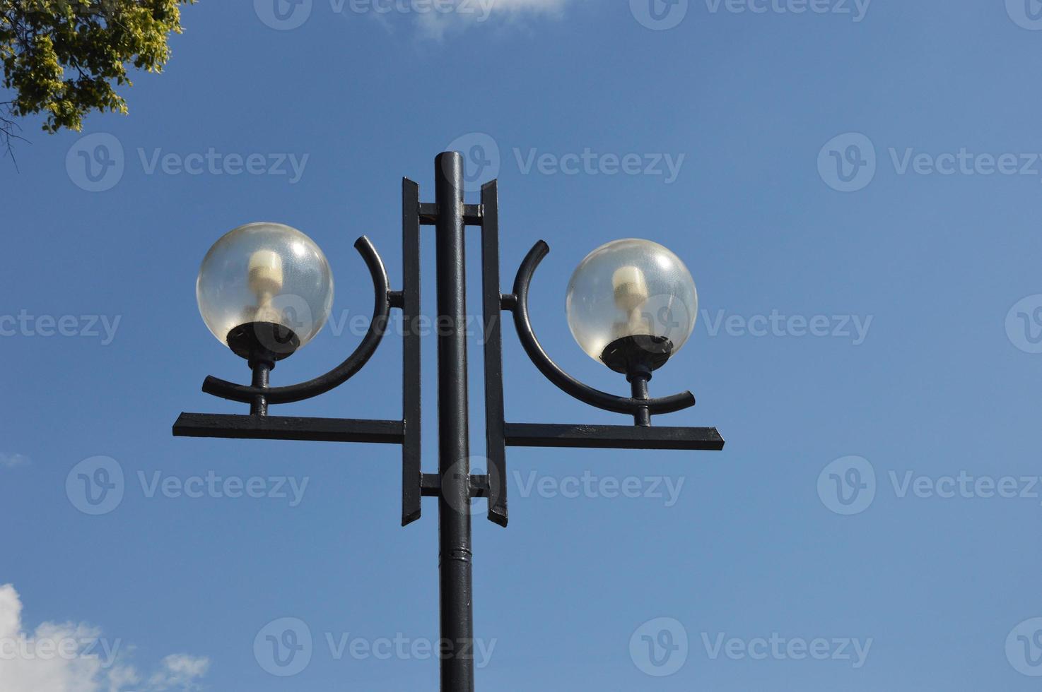 lampe ronde de rue, éclairage extérieur de la ville contre le ciel bleu et les nuages. photo