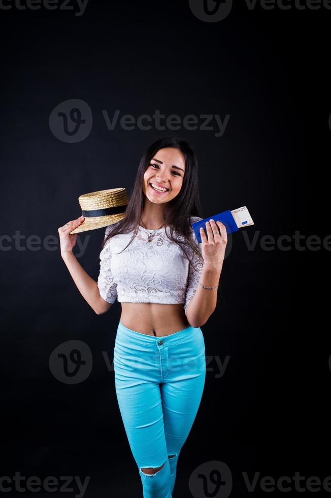 portrait d'une femme heureuse posant avec passeport et chapeau. photo