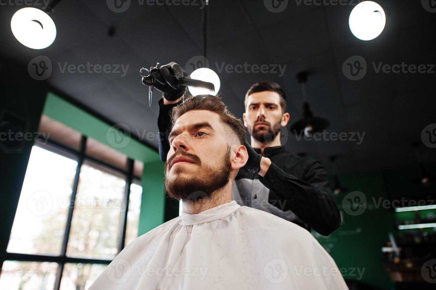 bel homme barbu au salon de coiffure, coiffeur au travail. photo