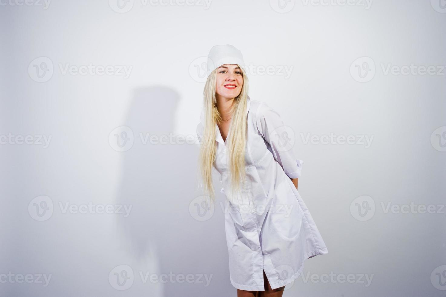 jolie blonde femme médecin ou infirmière en blouse de laboratoire isolée sur fond blanc. photo