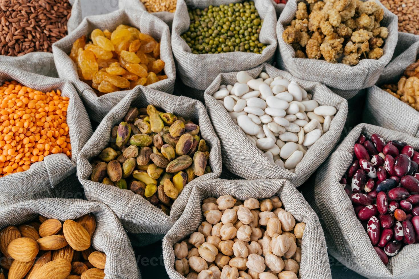 divers types de fruits secs et de céréales au marché des agriculteurs. haricot mungo, amande, mûre, pois chiches, raisins secs. photo en gros plan