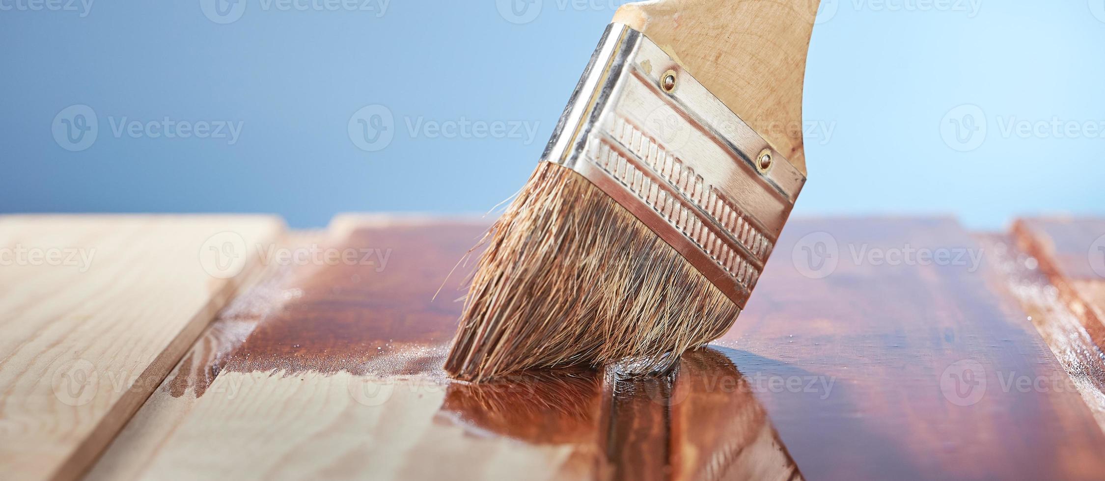 peinture parquet avec vernis de protection sur fond bleu. photo