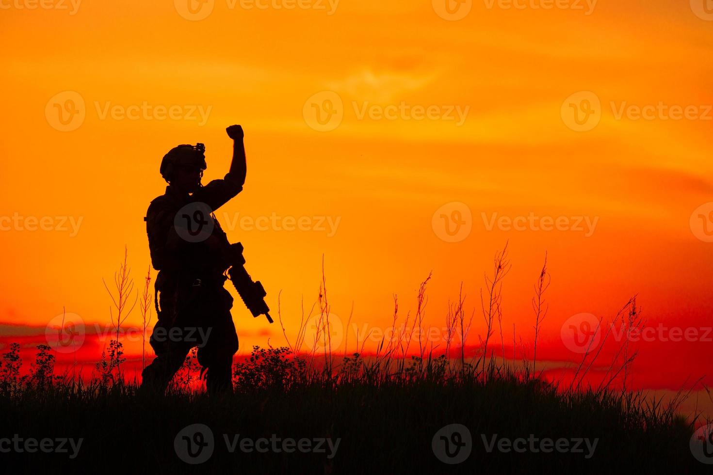 silhouette de soldat militaire ou officier avec des armes au coucher du soleil photo