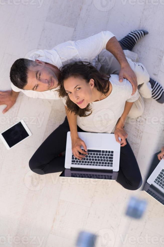 couple utilisant une tablette et un ordinateur portable vue de dessus photo