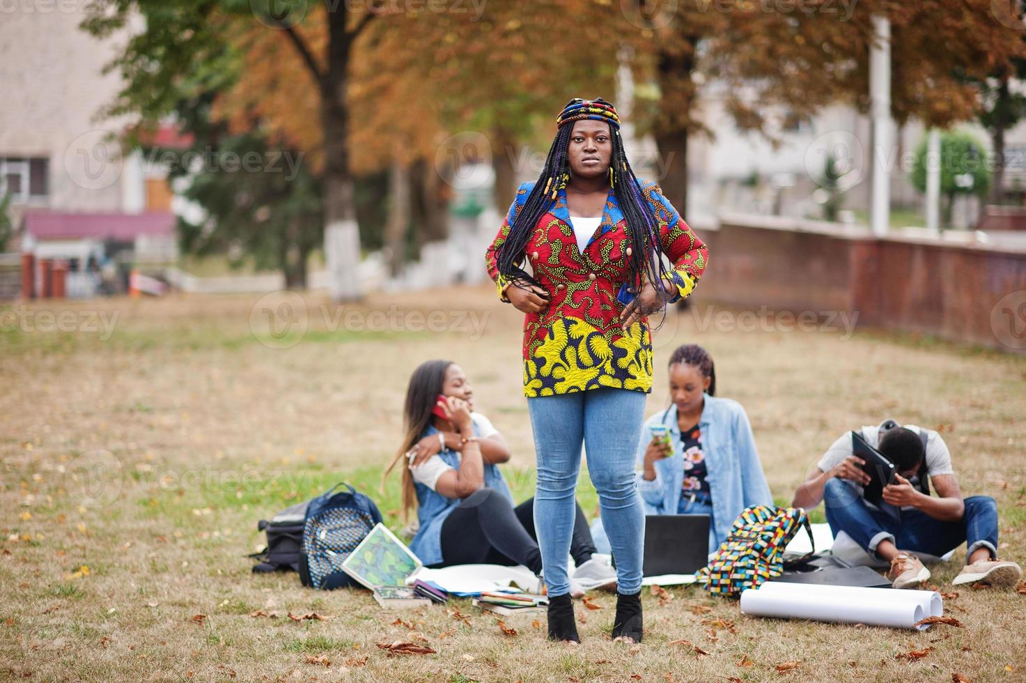 groupe de cinq étudiants africains qui passent du temps ensemble sur le campus de la cour universitaire. amis afro noirs qui étudient. thème de l'éducation. photo