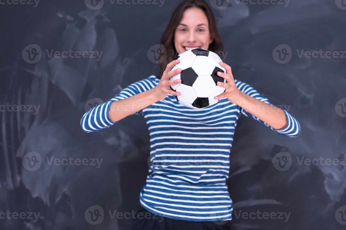 femme tenant un ballon de football devant une planche à dessin à la craie photo