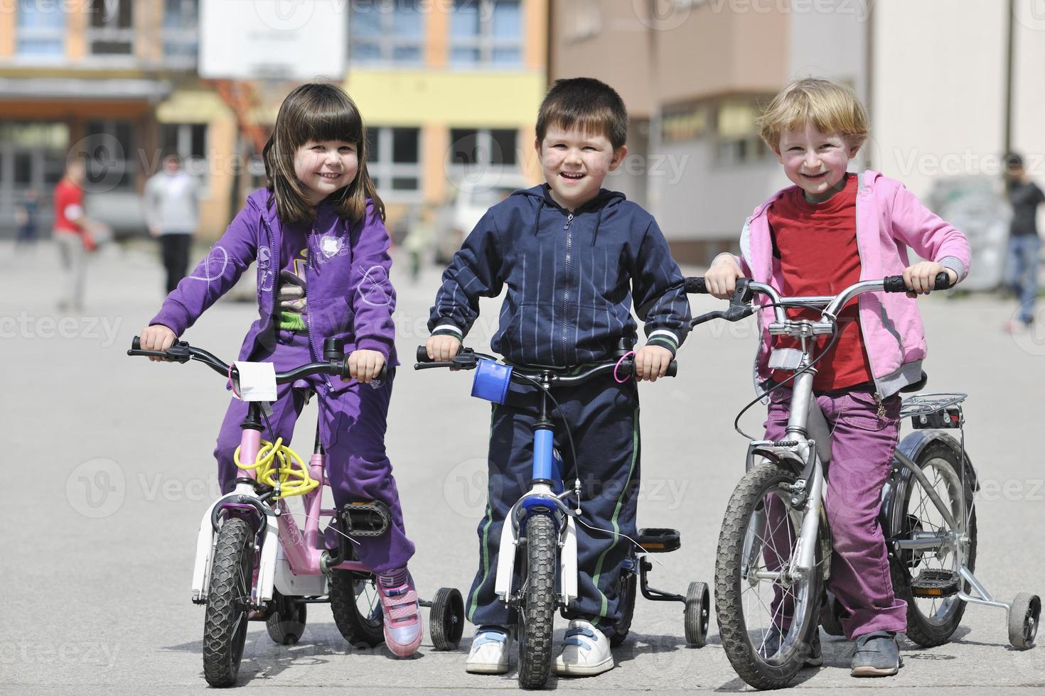 groupe d'enfants heureux apprenant à conduire un vélo photo