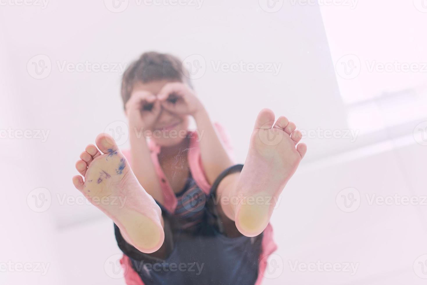 petit garçon debout sur un sol en verre transparent photo