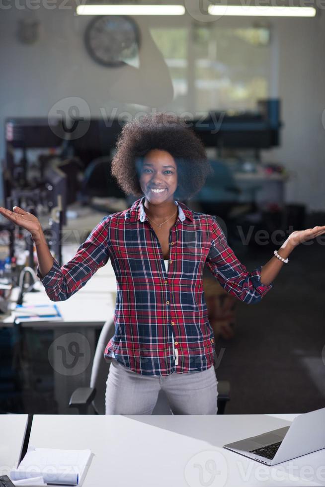 portrait d'une jeune femme afro-américaine réussie dans un bureau moderne photo