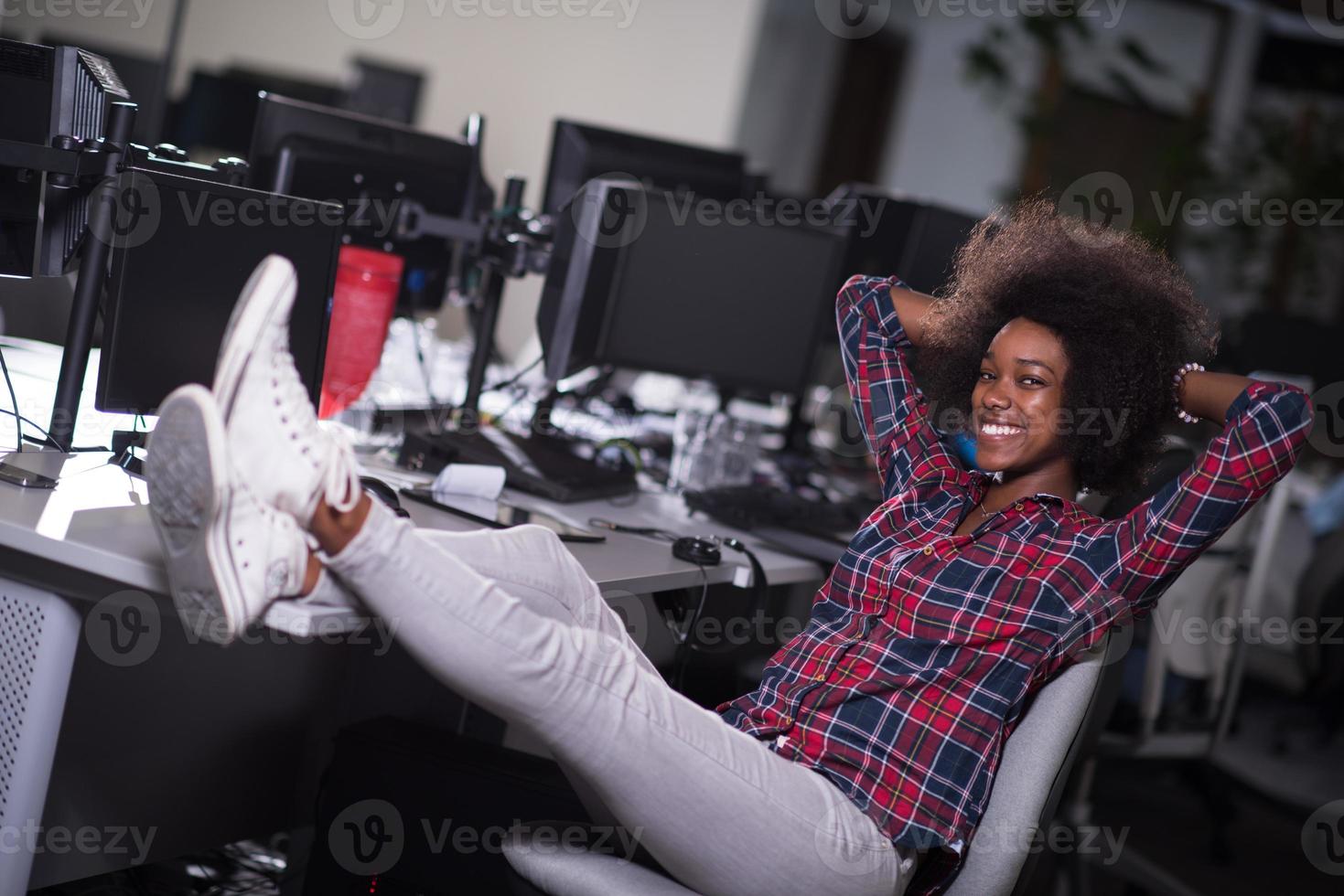 portrait d'une jeune femme afro-américaine réussie dans un bureau moderne photo