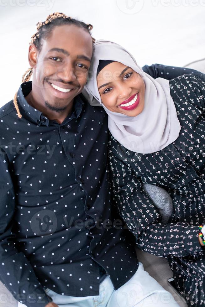 couple africain assis sur un canapé devant la télé ensemble photo