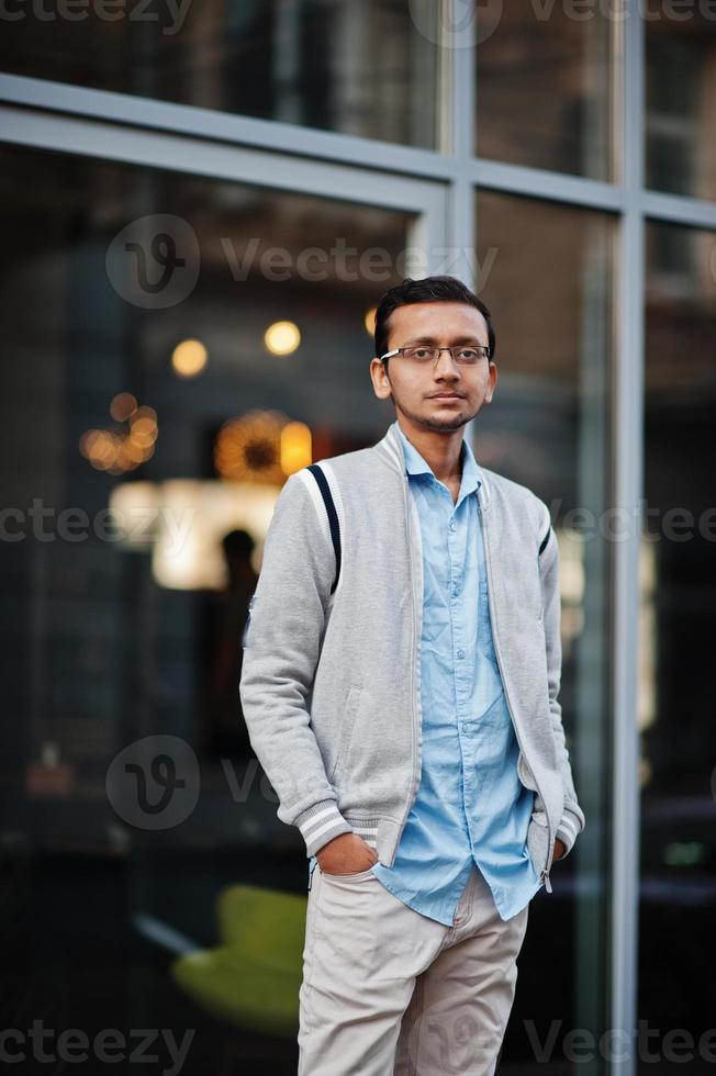 un étudiant indien sud-asiatique porte des lunettes et une pose décontractée en plein air. photo