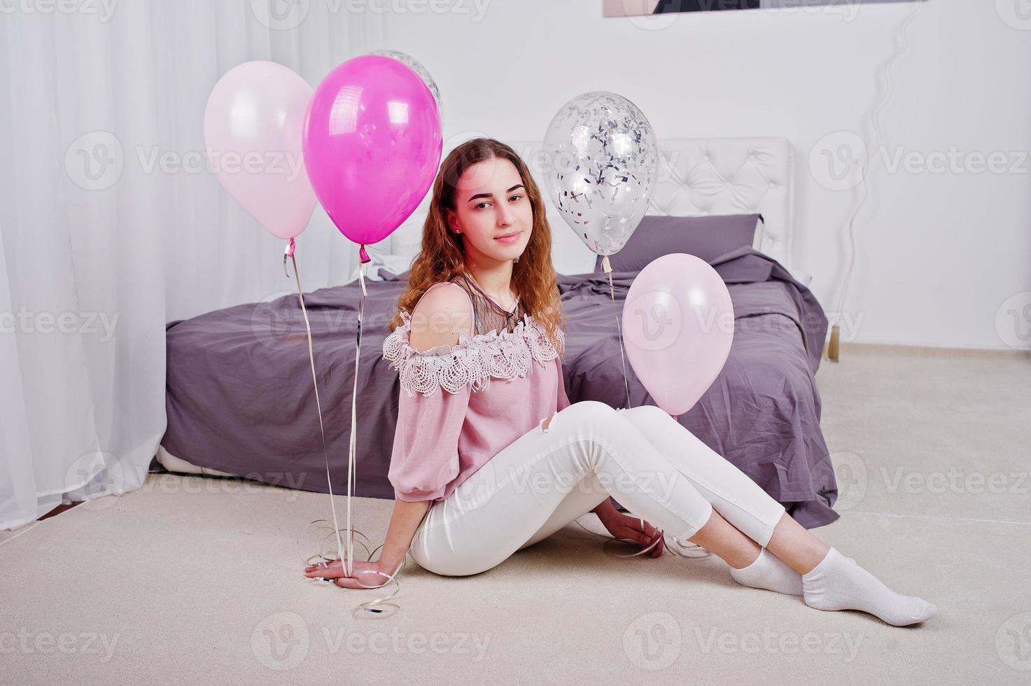 jeune fille avec des ballons sur le lit posé sur la salle de studio. photo