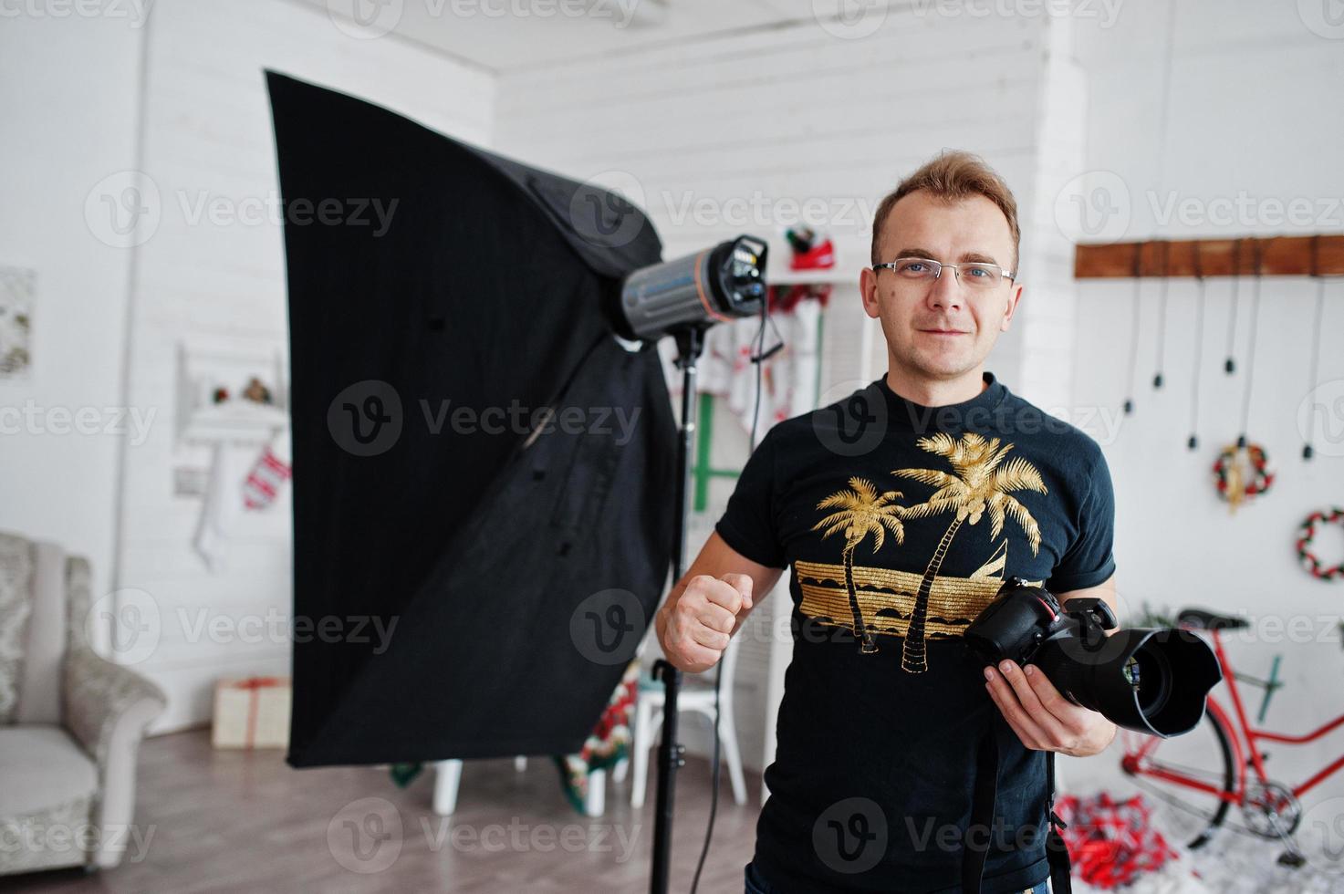 photographe à lunettes contre la lumière du flash sur studio. photo