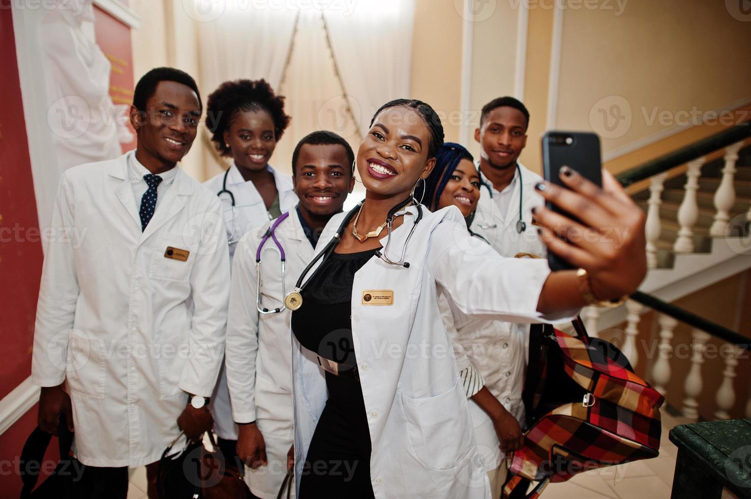 groupe d'étudiants en médecine africains à l'intérieur de l'université de médecine faisant du selfie au téléphone. photo