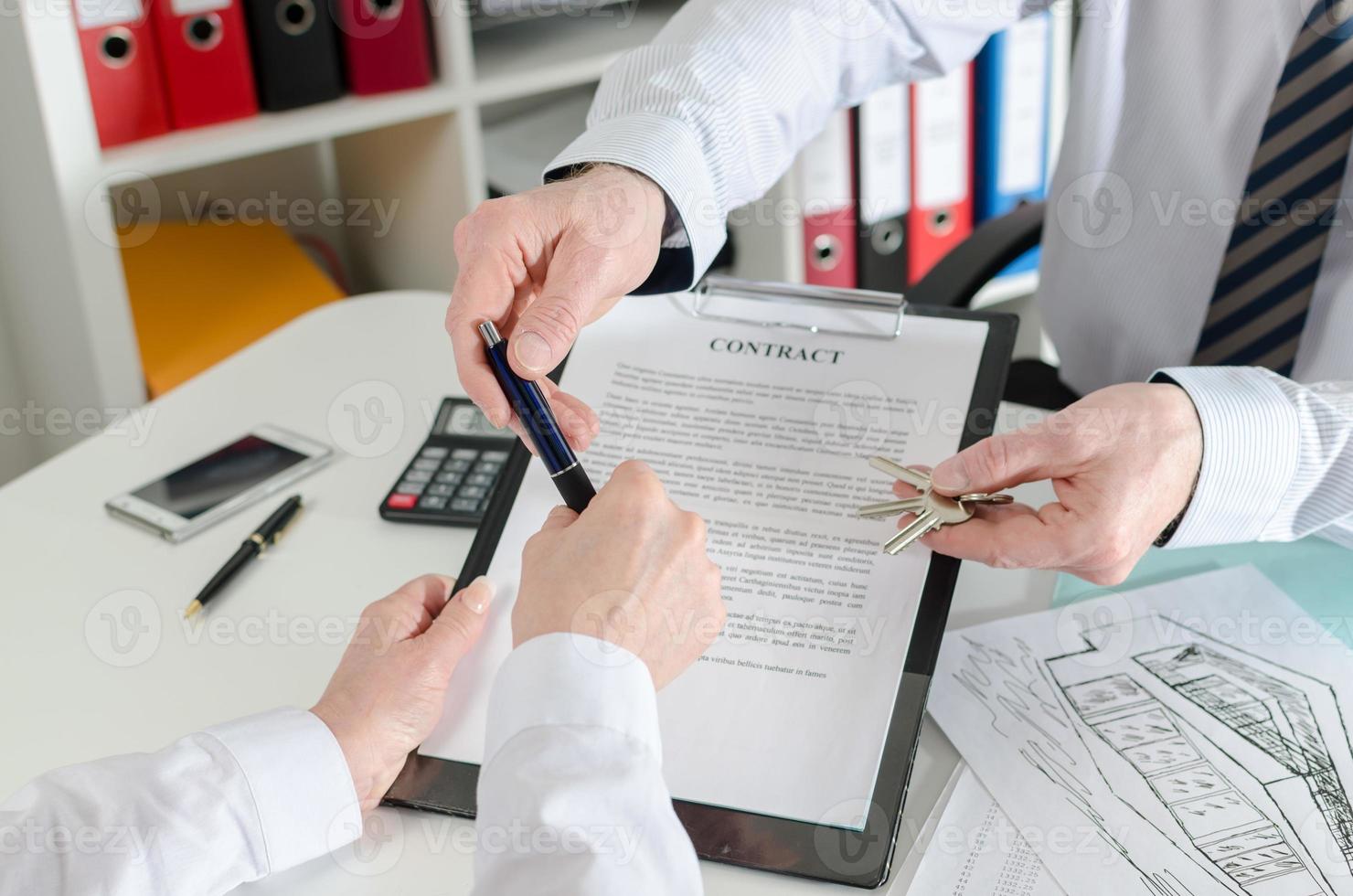 agent immobilier donnant un stylo à son client pour signer le contrat photo
