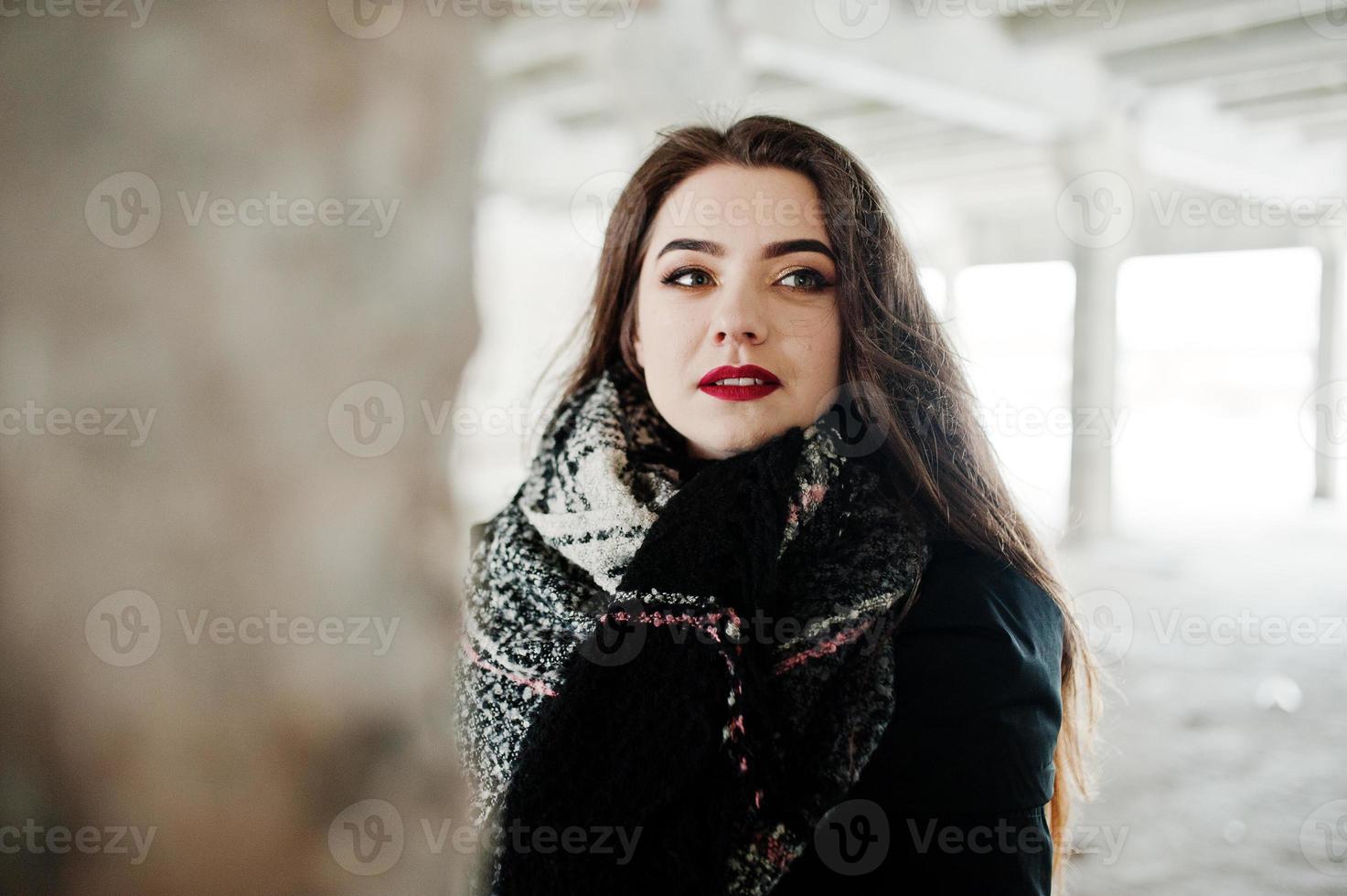 brune élégante fille décontractée en écharpe contre la place de l'usine abandonnée. photo