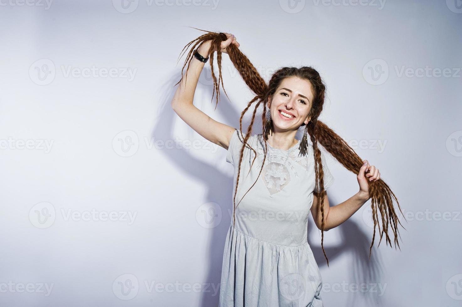 tournage en studio d'une fille en robe grise avec des nattes dreads sur fond blanc. photo