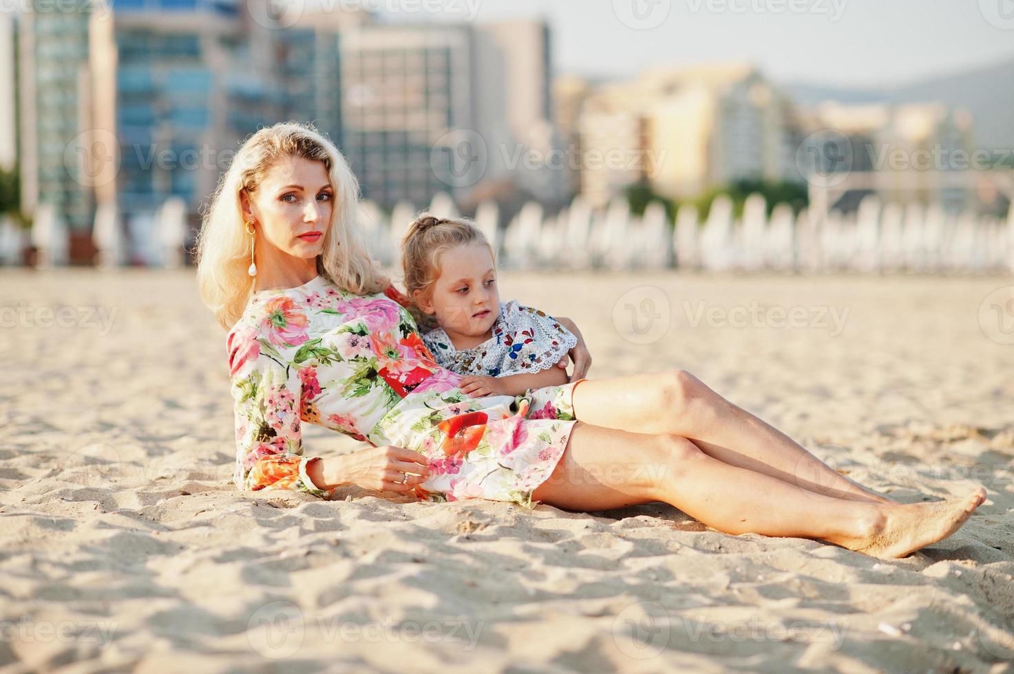 mère et belle fille s'amusant sur la plage. portrait d'une femme heureuse avec une jolie petite fille en vacances. photo
