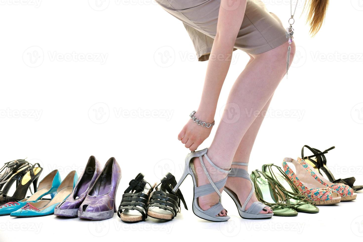 jolie jeune femme avec l'achat de chaussures de dépendance, isolé sur fond blanc photo