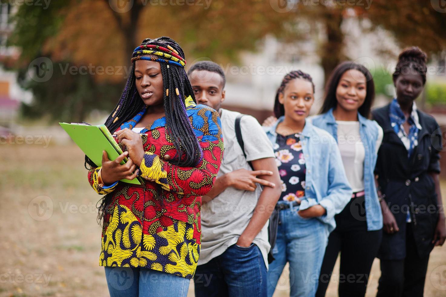 rangée d'étudiants africains du groupe cinq passant du temps ensemble sur le campus de la cour de l'université. amis afro noirs qui étudient. thème de l'éducation. photo