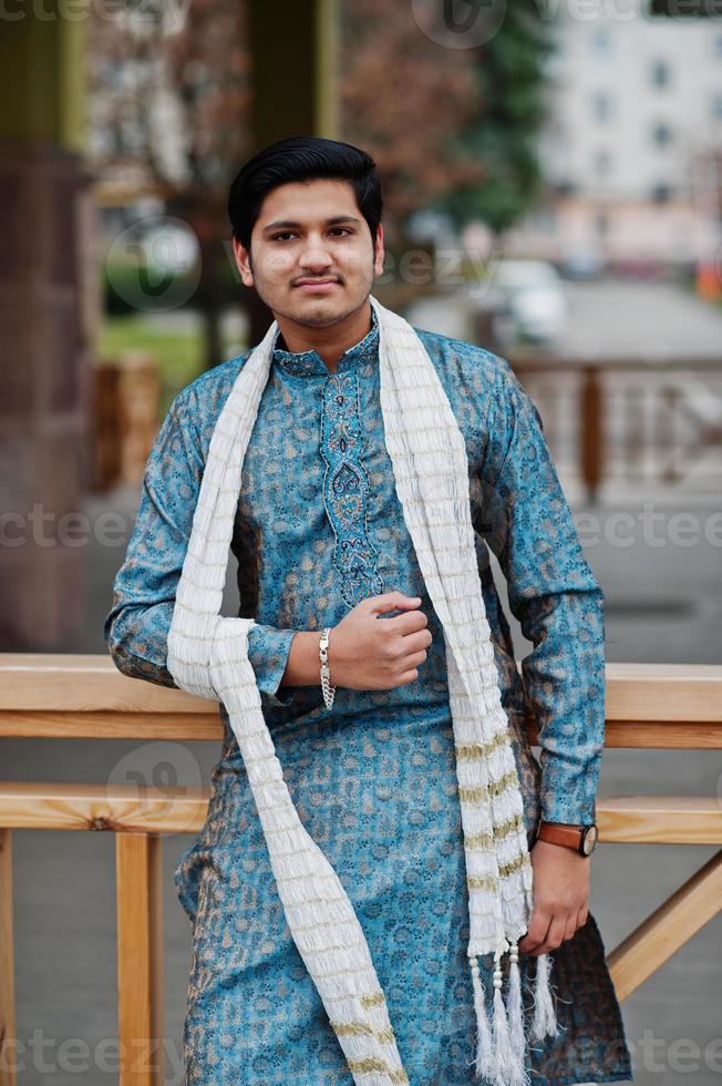 l'homme indien porte des vêtements traditionnels avec une écharpe blanche posée à l'extérieur. photo