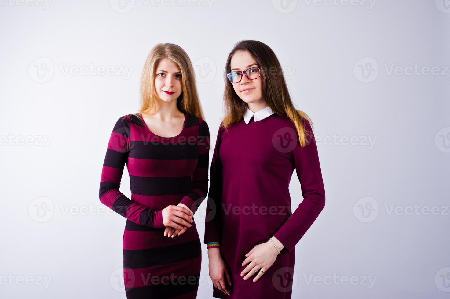 portrait de deux amies en robes de cerise posant en studio. photo
