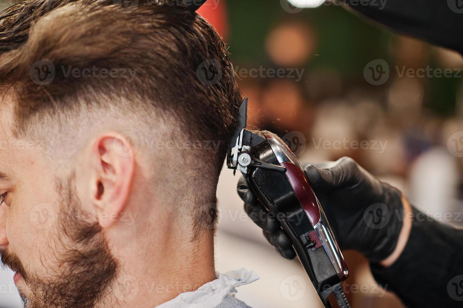 bel homme barbu au salon de coiffure, coiffeur au travail. fermer la nuque. photo