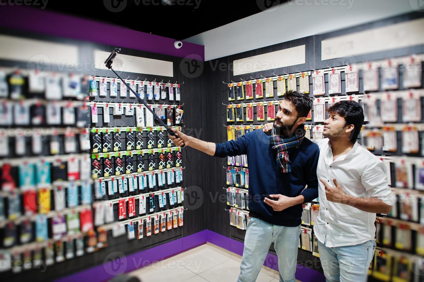 deux indiens mans client acheteur au téléphone mobile faisant selfie par bâton monopode. concept de peuples et de technologies d'asie du sud. magasin de téléphonie mobile. photo