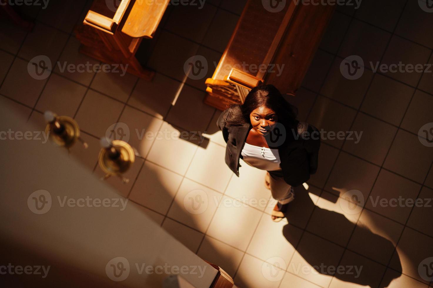 femme afro-américaine priant dans l'église. croyants médite dans la cathédrale et le temps spirituel de la prière. vue d'en-haut. photo