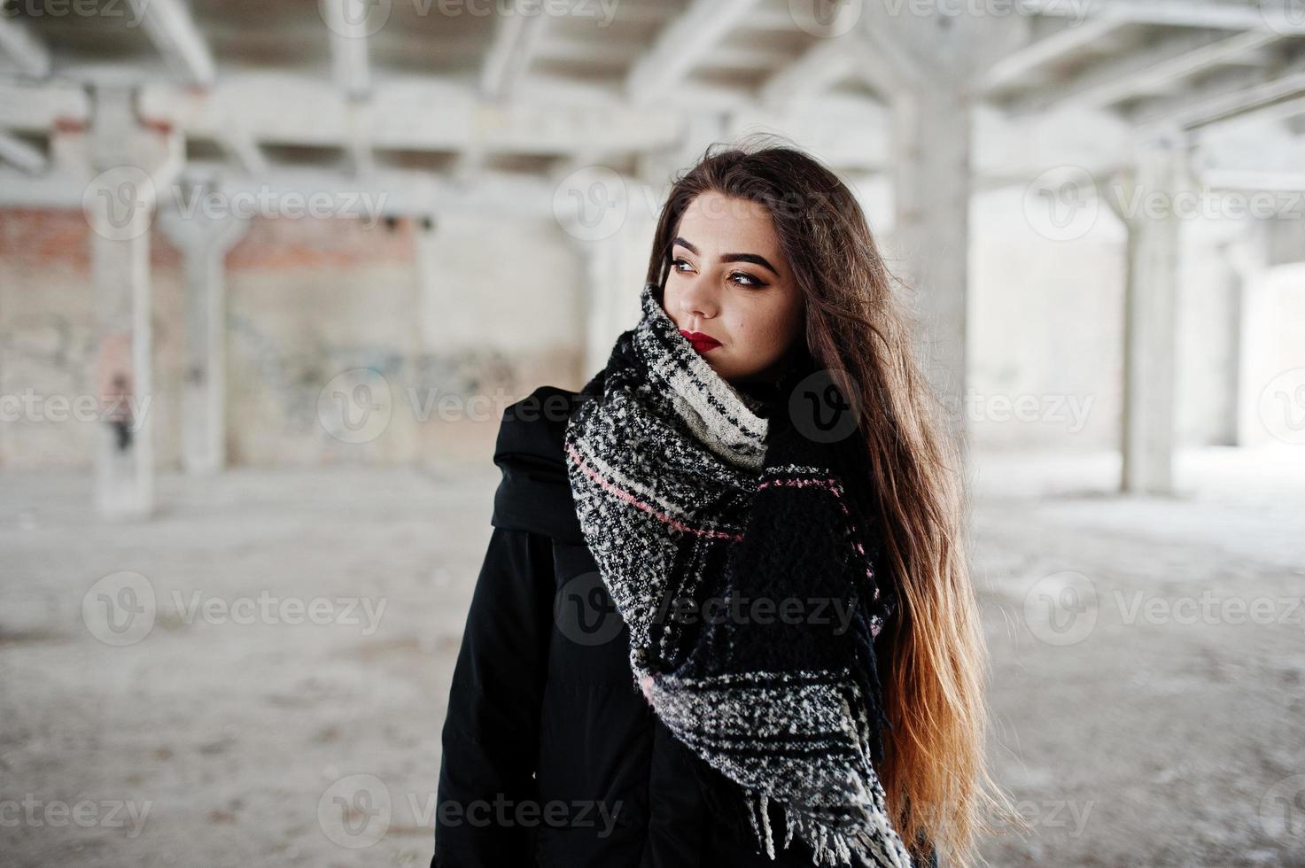 brune élégante fille décontractée en écharpe contre la place de l'usine abandonnée. photo