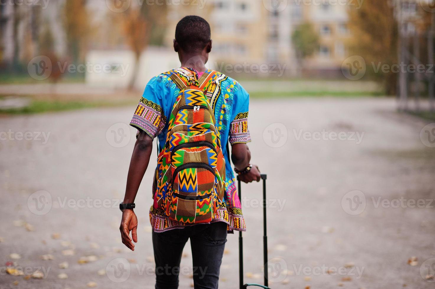 homme afro-américain en chemise à carreaux, avec valise et sac à dos.  voyageur d'homme noir au parc d'automne parlant au téléphone portable.  10570233 Photo de stock chez Vecteezy