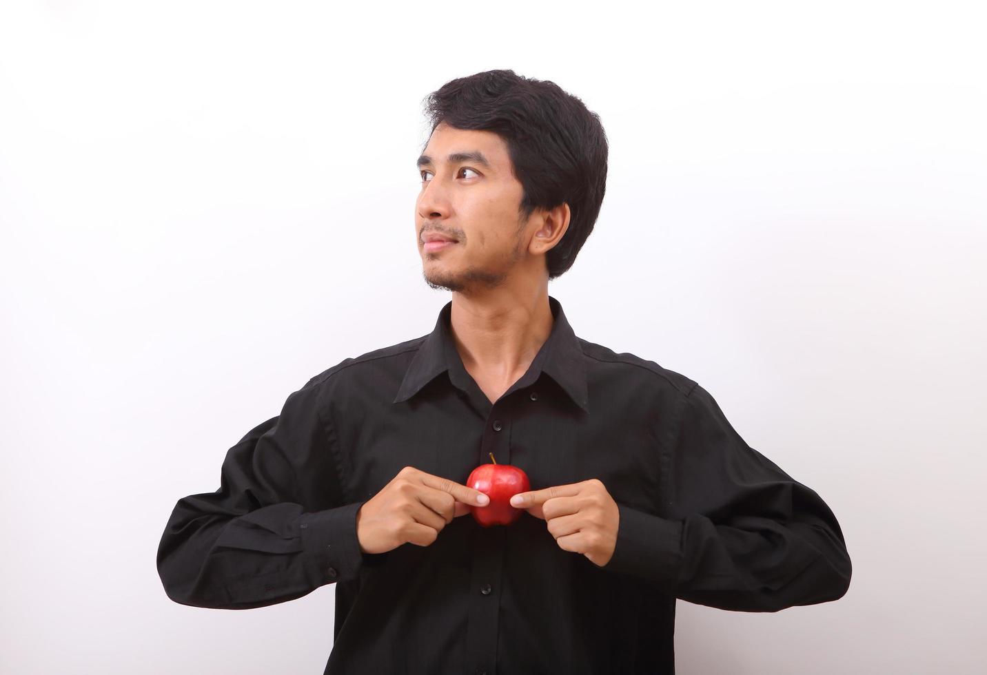 jeune homme en bonne santé mangeant une pomme rouge photo