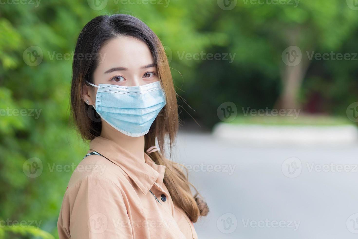coronavirus et pollution de l'air concept pm2.5. une jeune belle étudiante asiatique porte un masque pour prévenir le coronavirus. en marchant pour rentrer à la maison photo