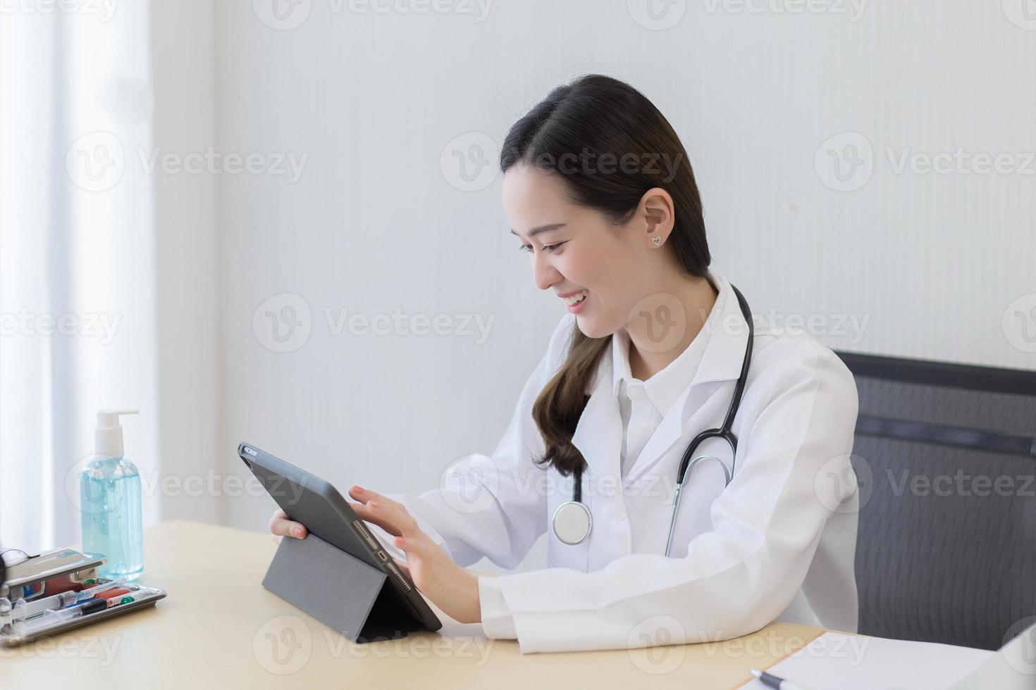 femme médecin asiatique à la recherche de données sur tablette. photo