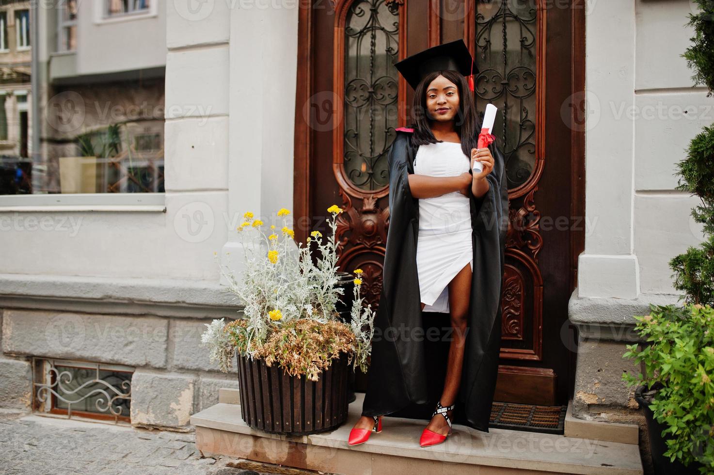 jeune étudiante afro-américaine avec diplôme pose à l'extérieur. photo