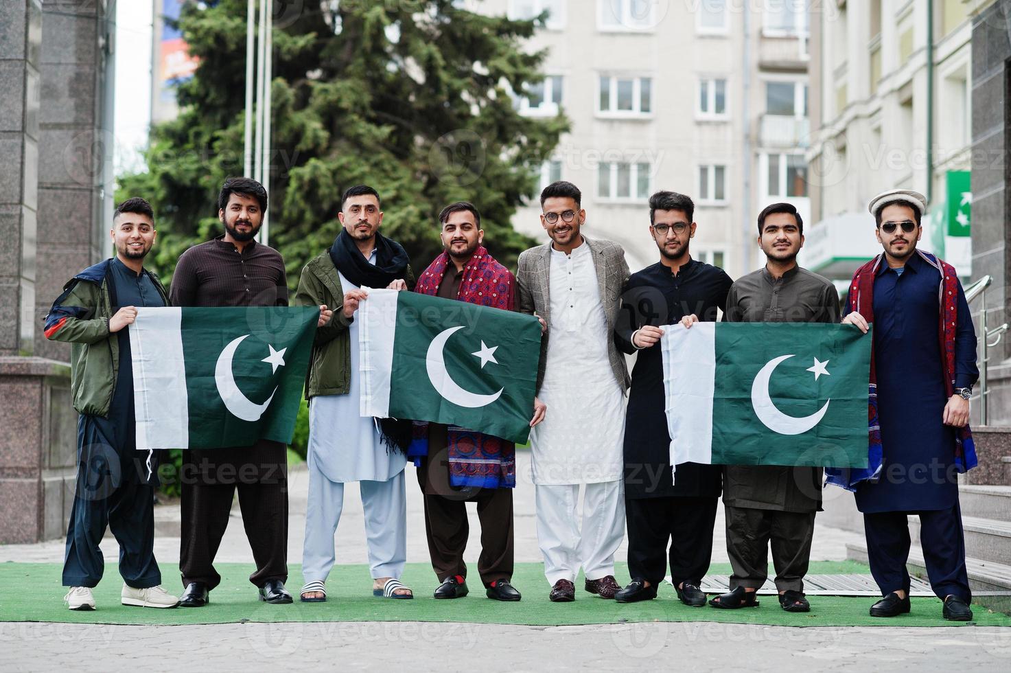 groupe d'hommes pakistanais portant des vêtements traditionnels salwar kameez ou kurta avec des drapeaux pakistanais. photo