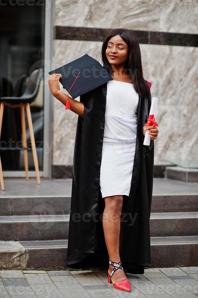 jeune étudiante afro-américaine avec diplôme pose à l'extérieur. photo