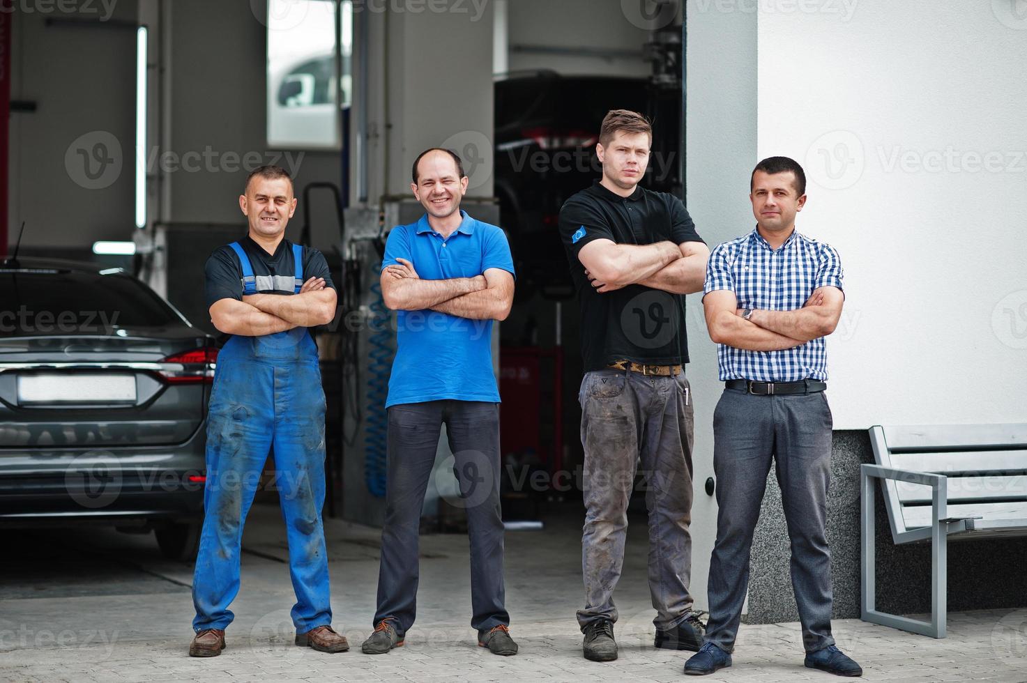 thème de la réparation et de l'entretien des voitures. trois mécaniciens et gérants en uniforme au service automobile. photo