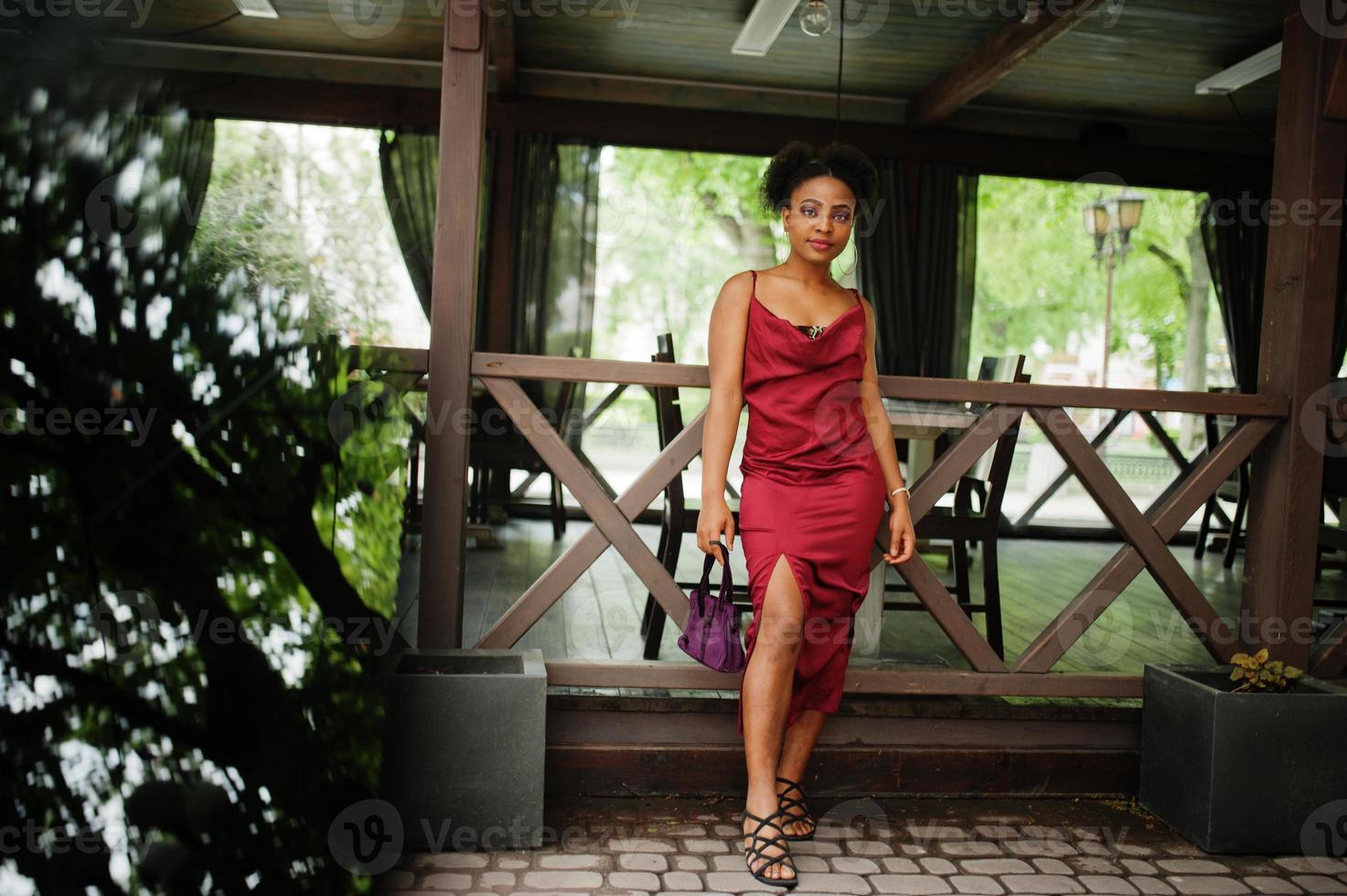 portrait d'une belle jeune femme africaine naturelle aux cheveux afro. modèle noir en robe de soie rouge. photo