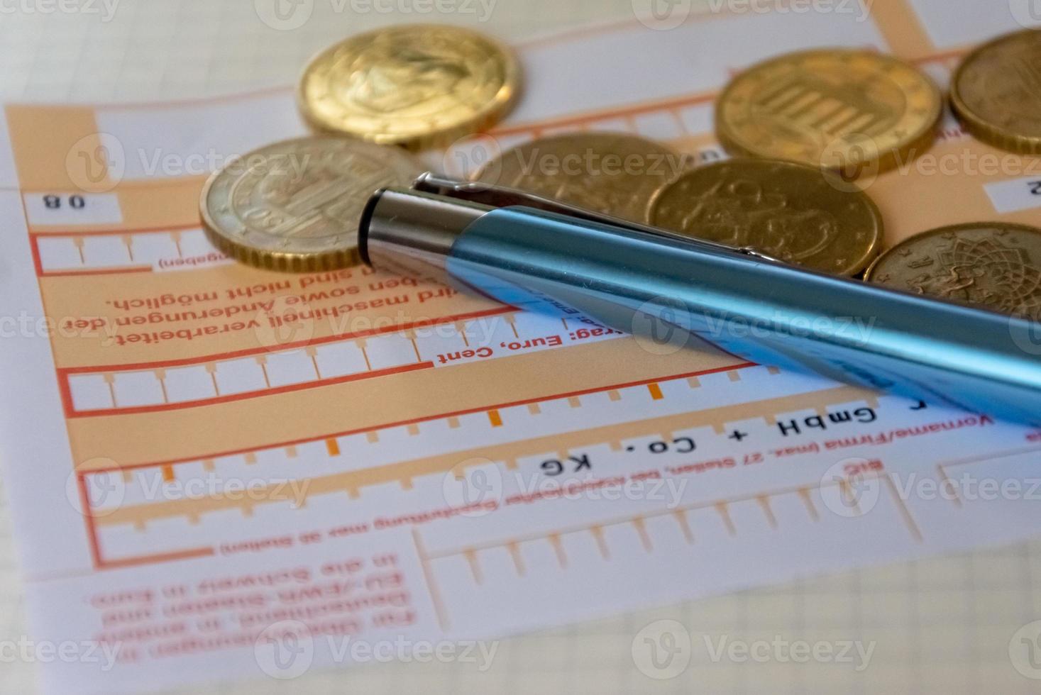 bordereau bancaire avec stylo et pièces en vrac photo