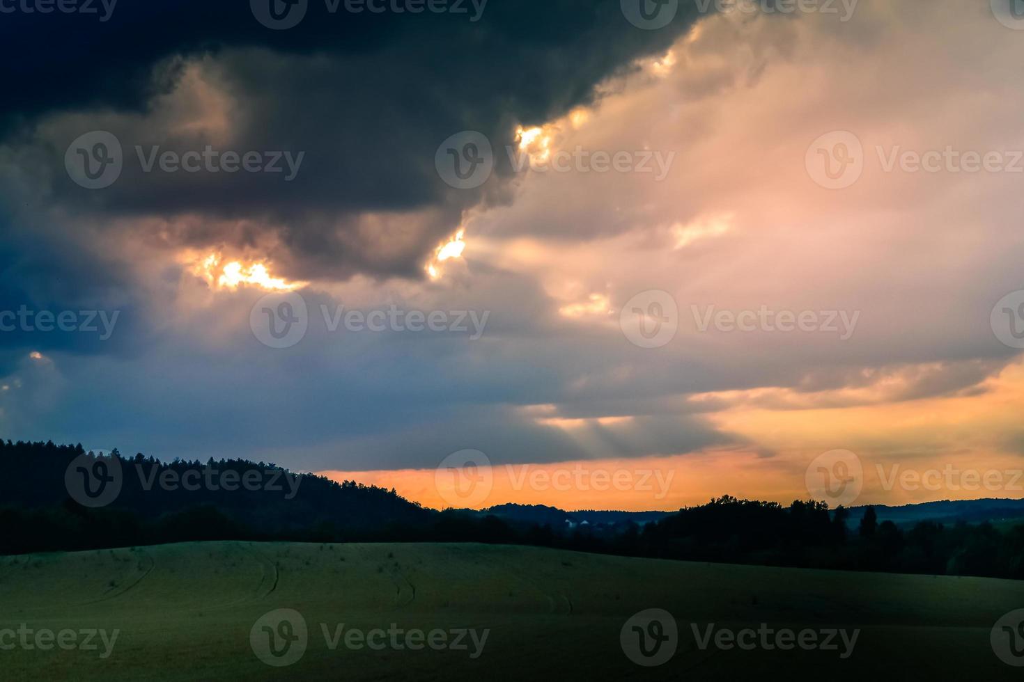 coucher de soleil orange avec des nuages sur un champ photo