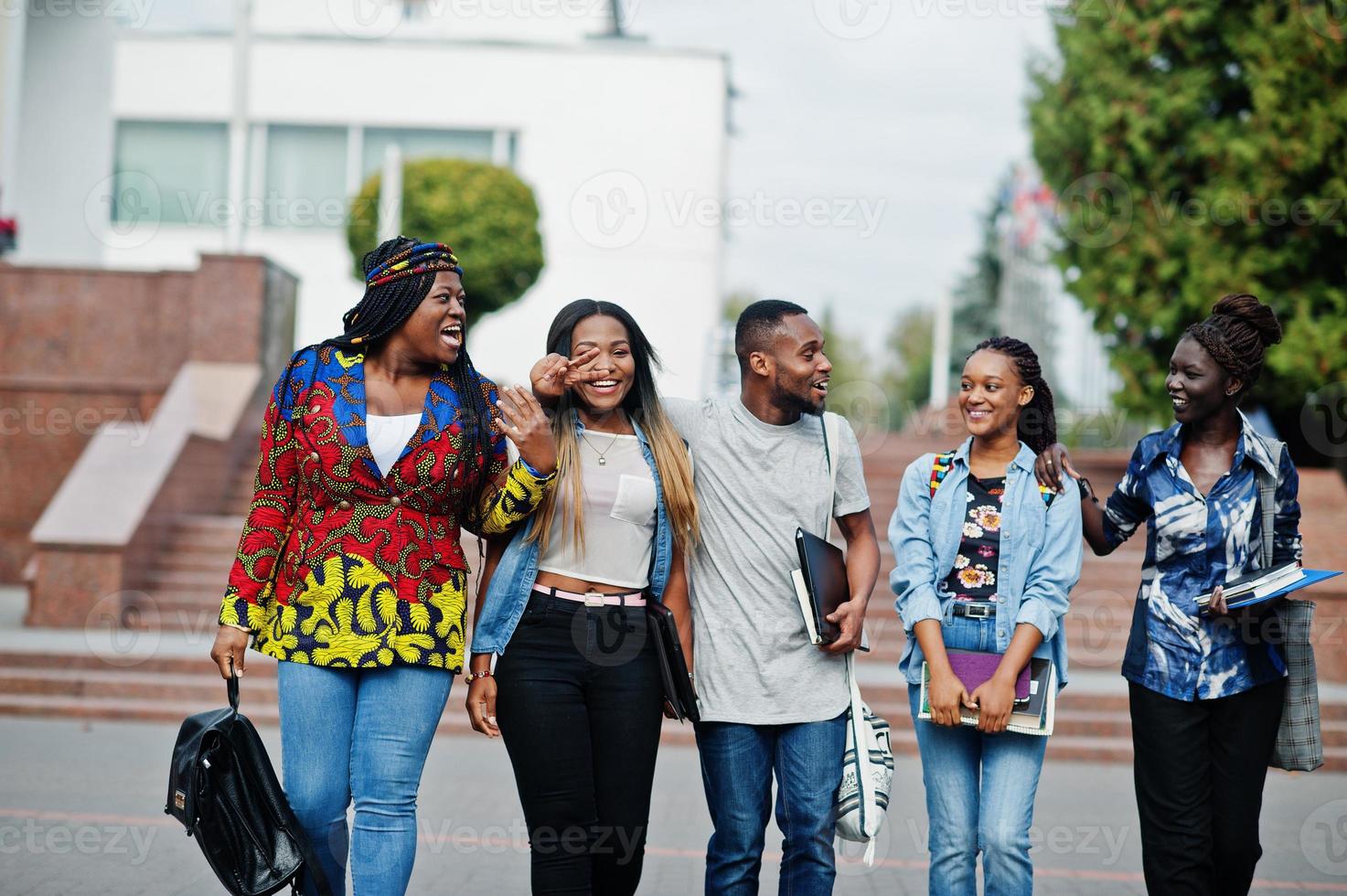 groupe de cinq étudiants africains qui passent du temps ensemble sur le campus de la cour universitaire. amis afro noirs qui étudient. thème de l'éducation. photo