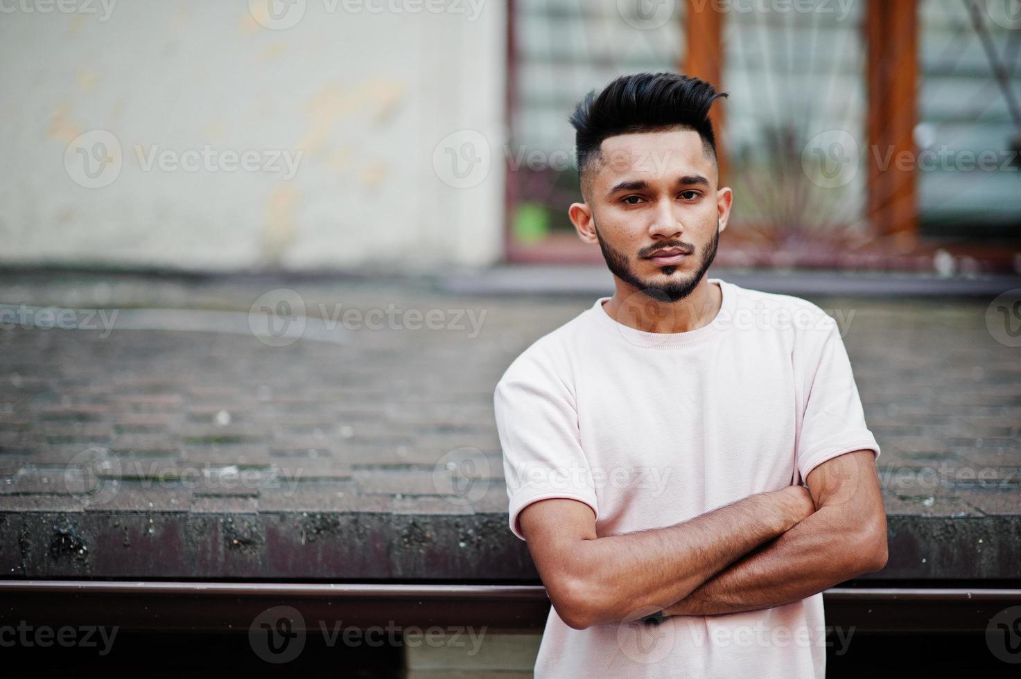 homme barbe indien élégant au t-shirt rose. modèle indien posé en plein air dans les rues de la ville. photo